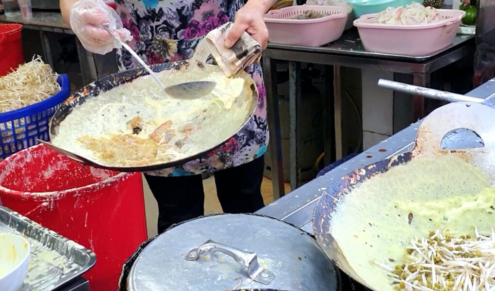 Making of banh seo in a wok.