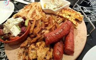 Aplate full of mixed grill items, sausage, chicken beast, haloumi cheese, greek salad nice fries , olives, etc