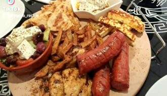 Aplate full of mixed grill items, sausage, chicken beast, haloumi cheese, greek salad nice fries , olives, etc